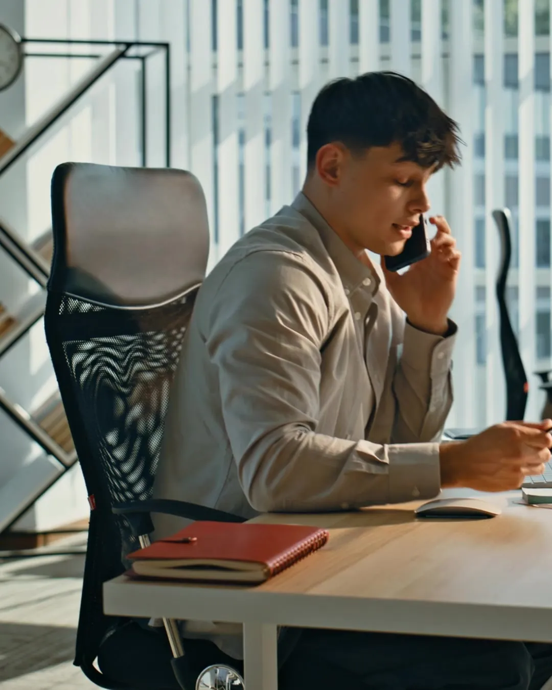 A salesman on a phone call at his desk