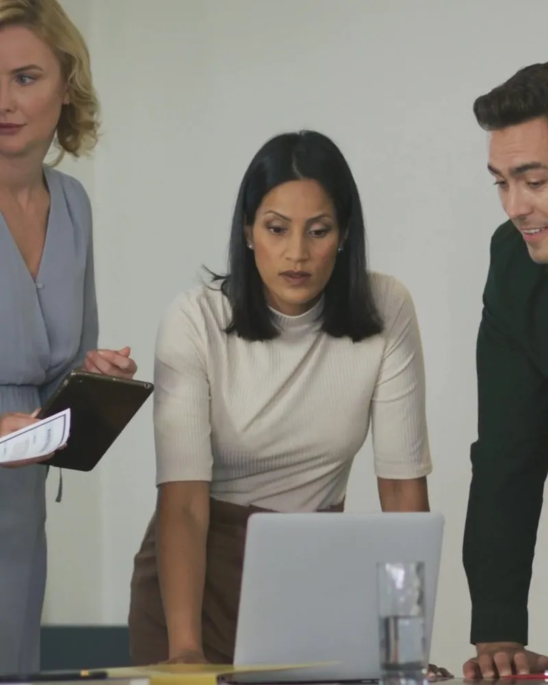 A team works through a plan together around a laptop