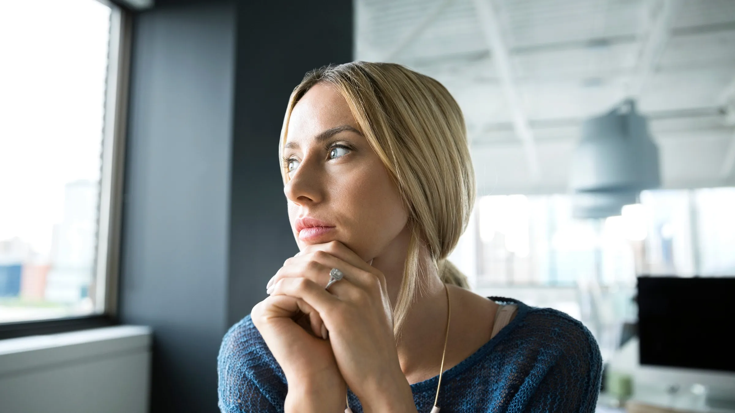 A woman thinking by an office window